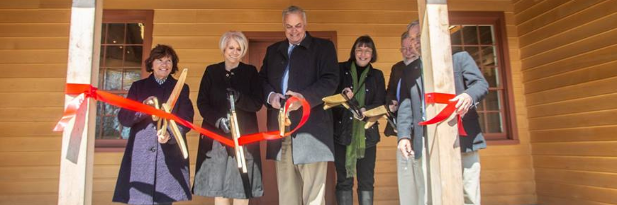 Photo of people standing cutting a ribbon